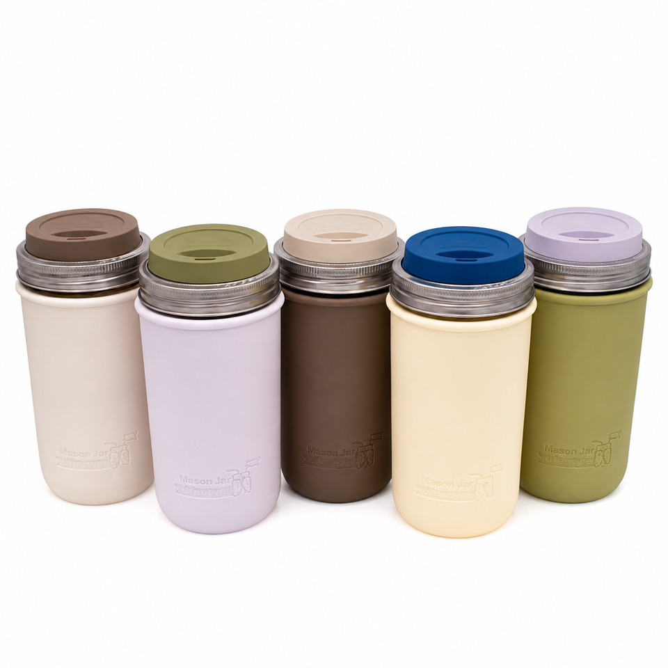 Five sample 24oz Mason jar travel tumblers with silicone sleeves in Greige, Light Orchid, Cocoa Brown, Butter Yellow, and Olive Green, assorted drinking lids, and stainless steel bands