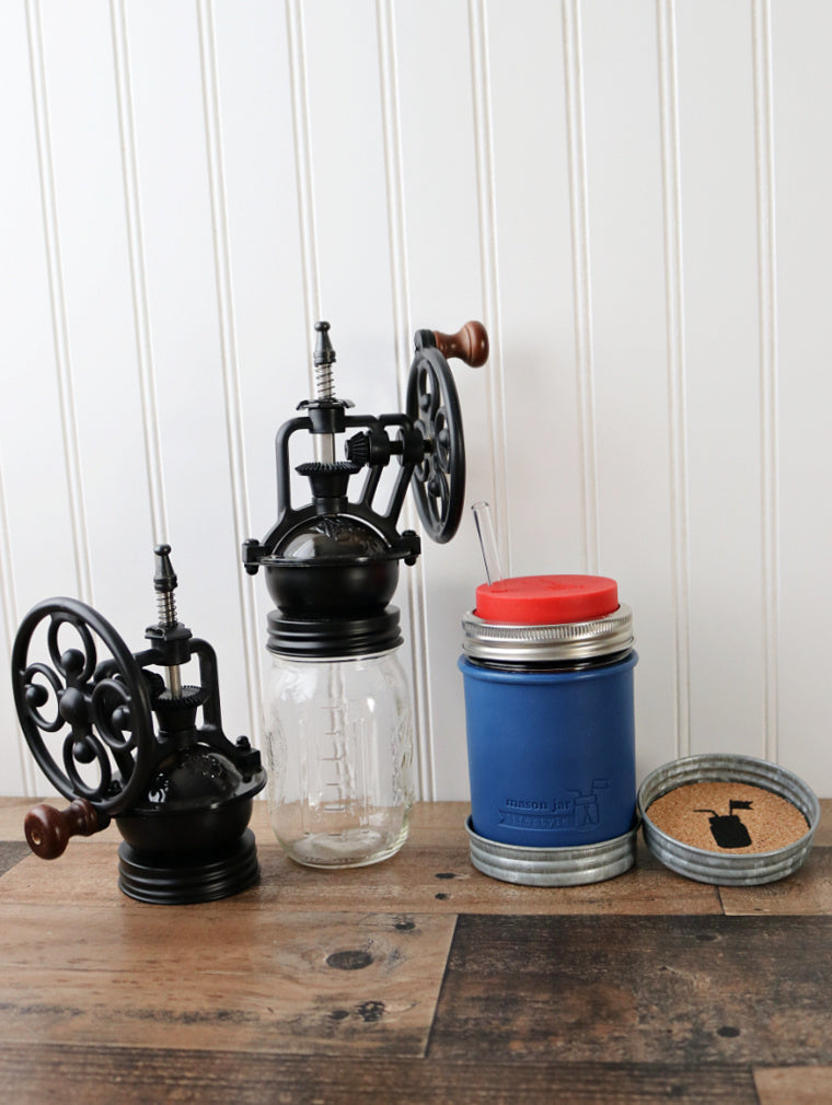 regular mouth vintage reproduction coffee grinders with deep blue wide mouth silicone pint sleeve, wide mouth cherry red silicone straw hole lid, and wide mouth galvanized lid cork coaster
