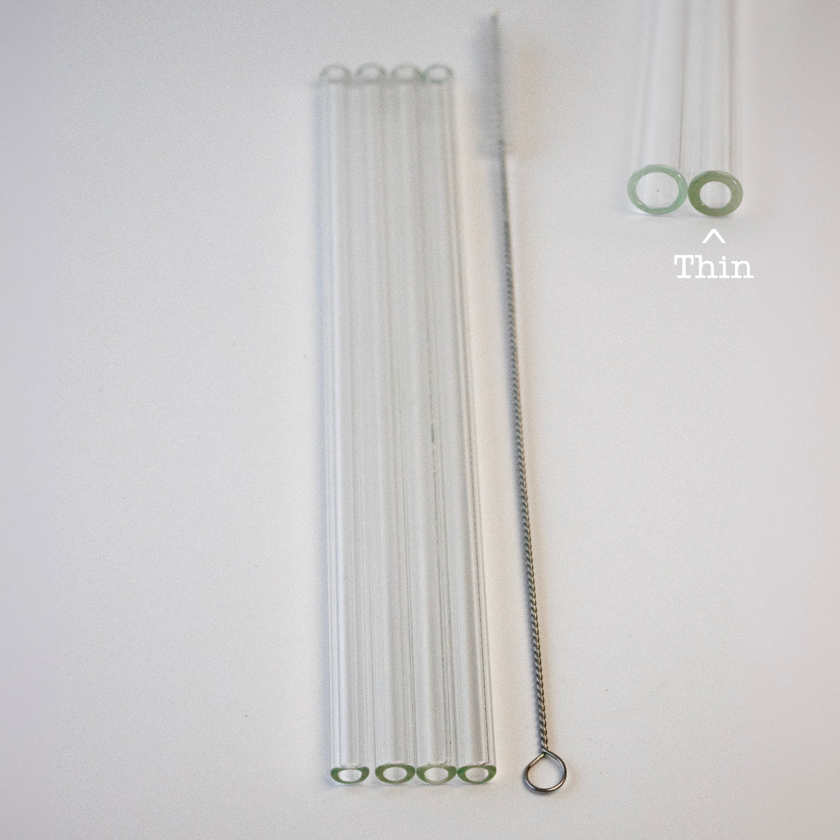 Thin set of four Long 9mm clear glass straws and one straw cleaner, with straw-end diameter comparison.