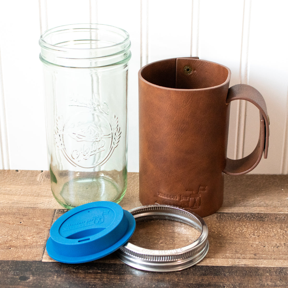 Pint and a half glass water bottle faux leather sleeve wide mouth drinking lid staged components
