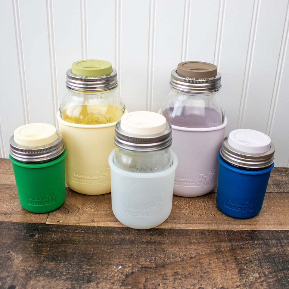 Wide Mouth silicone drinking lids with stainless steel bands on Mason jars with silicone sleeves.